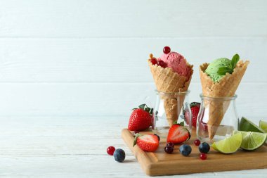 Dondurmalı koniler ve beyaz ahşap arka planda malzemeler.