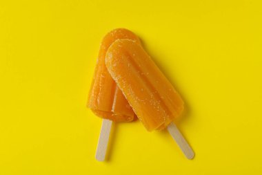 Sarı arka planda mango dondurması var.