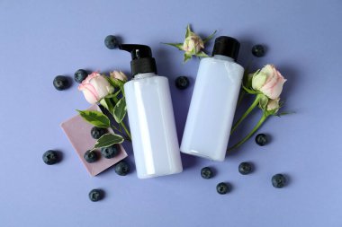 Doğal duş jeli ve mor arka plandaki malzemeler