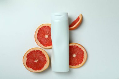 Beyaz arka planda duş jeli ve greyfurt dilimleri