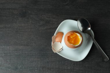 Lezzetli kahvaltı kavramı. Kaynamış yumurta ve koyu ahşap masa.