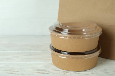 Kâğıt kaseler ve kağıt torba beyaz ahşap masada.