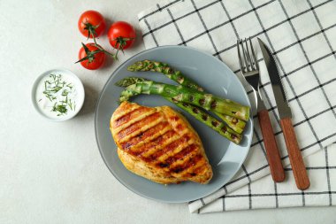 Beyaz desenli masada ızgara tavuk etiyle lezzetli yemek kavramı.