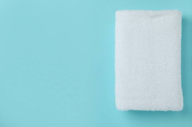 Mavi arkaplanda beyaz katlanmış havlu, metin için boşluk