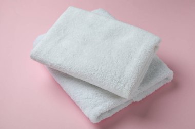 Pembe arka planda katlanmış temiz havlular, kapatın.