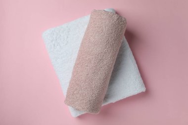 Pembe arka planda katlanmış temiz havlular, üst manzara