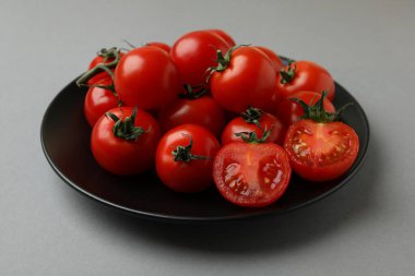 Gri arka planda vişneli domates tabağı