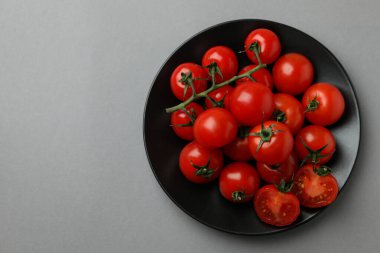 Gri arka planda vişneli domates tabağı