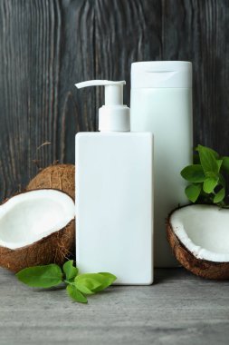 Duş jelleri ve hindistan cevizi ahşap arka planda