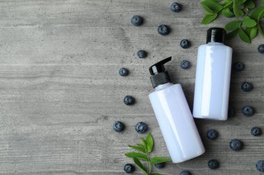 Gri desenli arka planda duş jelleri ve yaban mersini