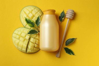 Doğal mango duş jeli ve sarı arka plandaki malzemeler.
