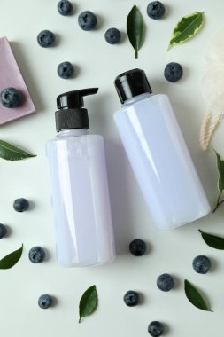 Beyaz arka planda doğal banyo kozmetikleri ve yabanmersini.