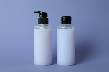 Menekşe arkaplanda boş duş jeli şişeleri