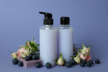 Doğal duş jeli ve mor arka plandaki malzemeler