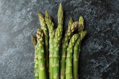 Siyah dumanlı arka planda taze yeşil kuşkonmaz