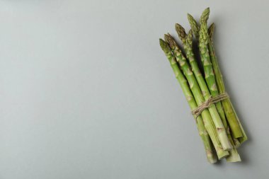 Açık gri arka planda bir sürü taze kuşkonmaz