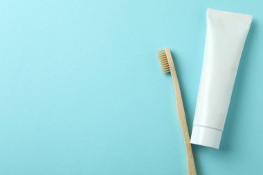 Mavi arka planda çevre dostu diş fırçası ve diş macunu tüpü