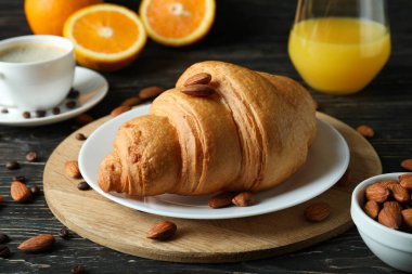 Tahta arka planda kruvasanla lezzetli kahvaltı kavramı