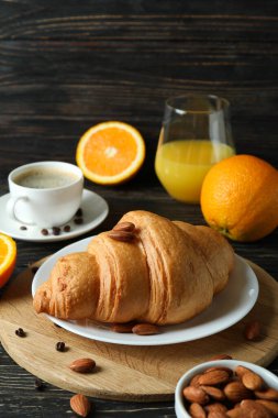 Tahta arka planda kruvasanla lezzetli kahvaltı kavramı