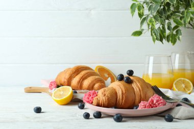 Beyaz ahşap arka planda kruvasan ile lezzetli kahvaltı kavramı