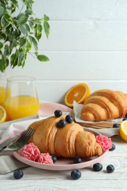 Beyaz ahşap arka planda kruvasan ile lezzetli kahvaltı kavramı