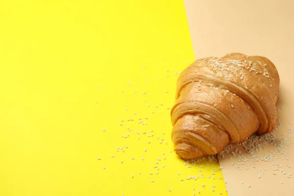 Croissant and sesame on two tone background, space for text