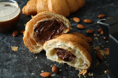 Koyu arkaplanda çikolatalı kruvasanla lezzetli kahvaltı kavramı