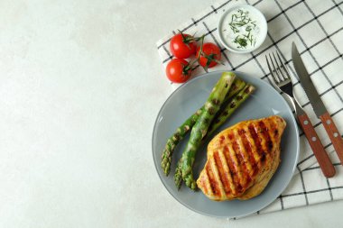 Beyaz desenli masada ızgara tavuk etiyle lezzetli yemek kavramı.