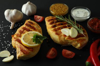 Izgara tavuk eti ve malzemeler siyah arka planda, kapatın.