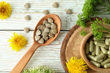 Beyaz ahşap masa üzerinde bitkisel ilaç hapları konsepti.