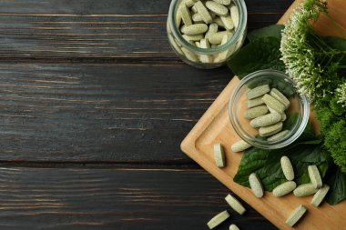 Ahşap masa üzerinde bitkisel ilaç hapları kavramı, metin için boşluk