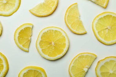 Beyaz zemin üzerinde olgun limon dilimleri, üst görünüm