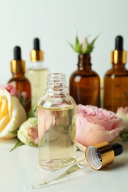 Beyaz arka planda gül yağı içeren cilt bakımı kavramı