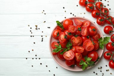 Beyaz ahşap arka planda vişneli domates tabağı