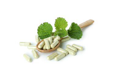 Beyaz arka planda izole edilmiş bitkisel toz kapsüllü kaşık