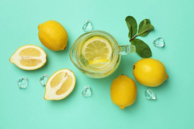 Arka planda bir sürahi limonata ve limon.