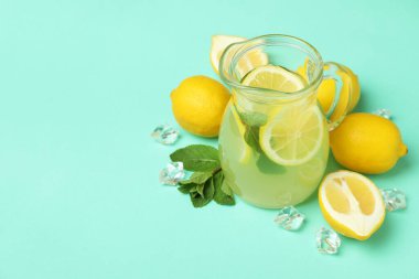 Arka planda bir sürahi limonata ve limon.