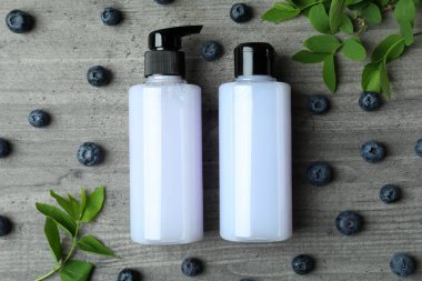 Gri desenli arka planda duş jelleri ve yaban mersini