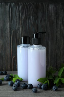 Duş jelleri ve böğürtlen ahşap arka planda