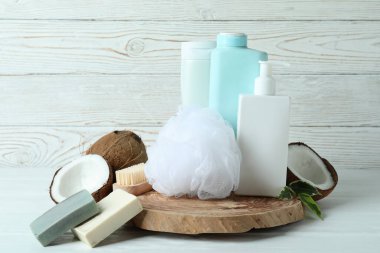 Beyaz ahşap arka planda banyo kozmetiği ve hindistan cevizi
