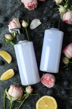 Doğal duş jelleri ve siyah dumanlı arka plandaki malzemeler