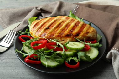 Gri desenli masada kızarmış tavuklu salata.
