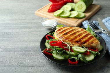 Gri desenli masada kızarmış tavuklu salata.