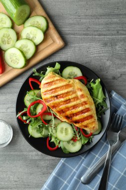 Gri desenli masada kızarmış tavuklu salata.