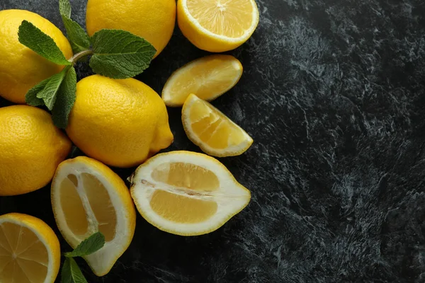 Ripe lemons on black smokey background, space for text