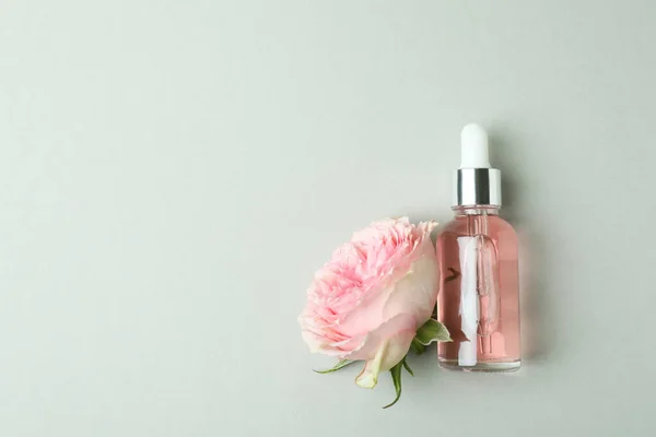 Flasche Mit Ätherischem Rosenöl Und Rose Auf Hellgrauem Hintergrund — Stockfoto
