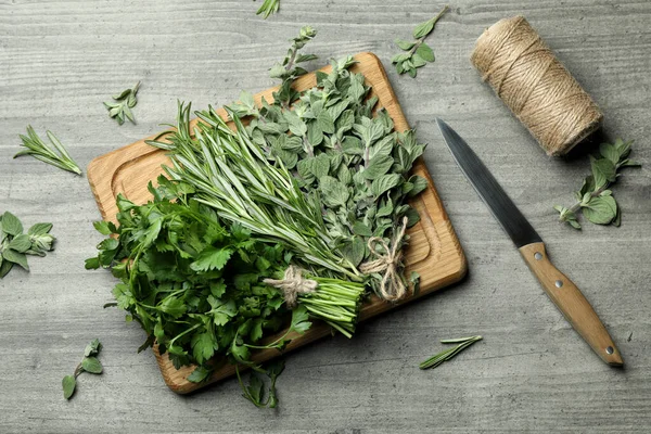 Fresh herbs on gray textured table, top view