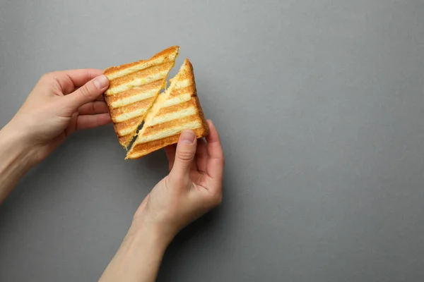 Weibliche Hände Halten Gegrilltes Sandwich Mit Käse Auf Grauem Hintergrund — Stockfoto