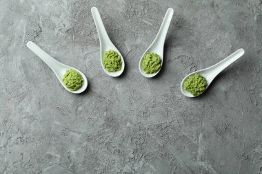 Gri desenli arka planda wasabi ile seramik kaşıklar
