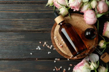 Ahşap masa üzerinde gül yağı içeren cilt bakımı kavramı